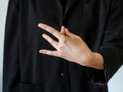 Close up of hands resting on knees in a mudra.